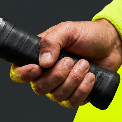 Close-up of a single Courterra Black X-PRO overgrip roll showing the professional finish and moisture-wicking Polyurethane material.