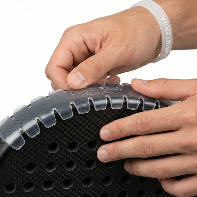 Close-up of athlete hands applying Courterra sawtooth edge protector to a carbon fiber padel racket showing wrinkle-free installation.